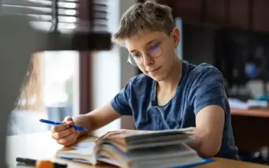 Middle school student reading and taking notes