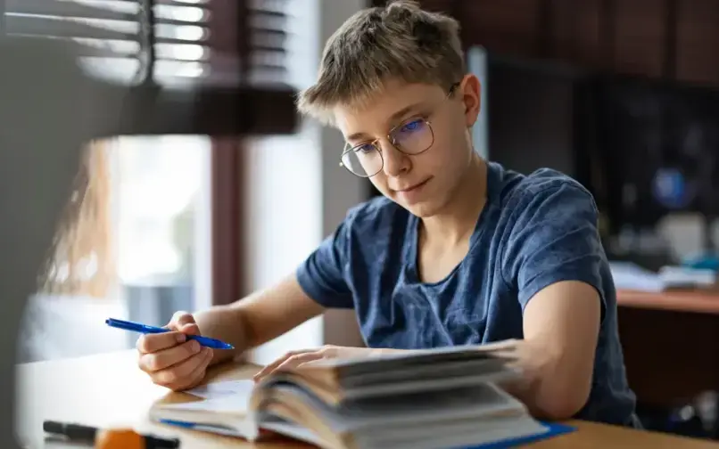 Middle school student reading and taking notes