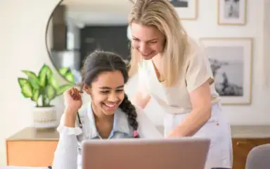 Mother and daughter working together with their laptop
