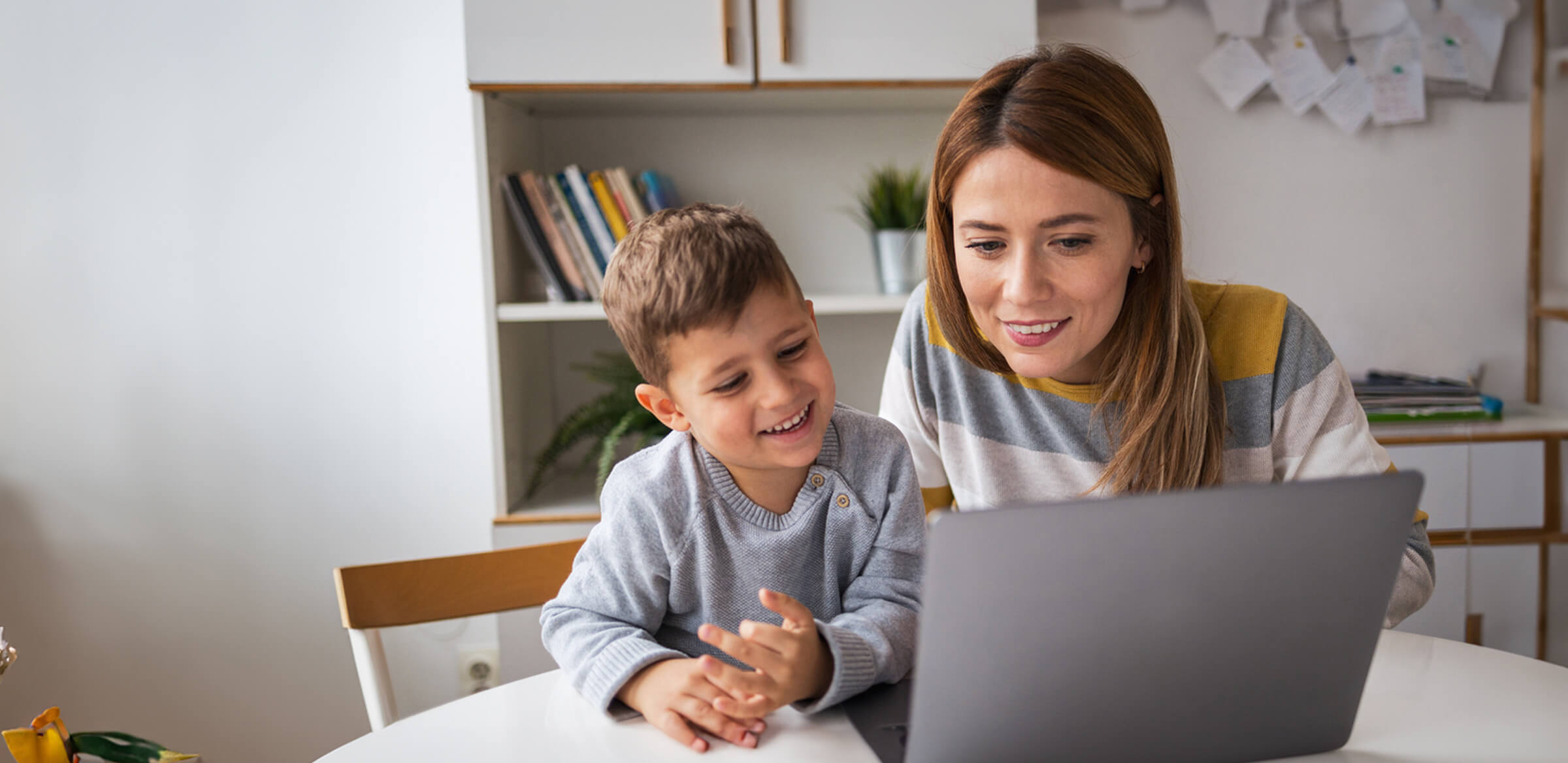 Mother and her son working together with their laptop